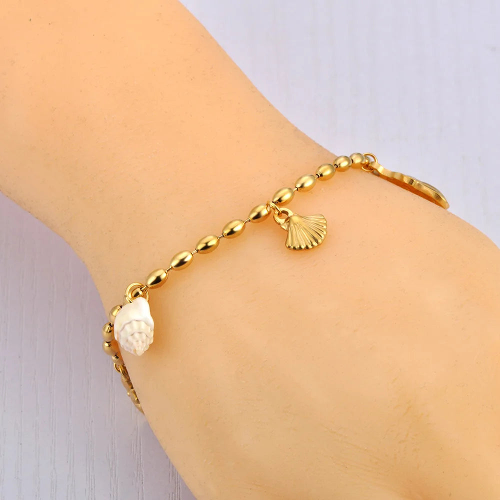 Bracelet doré à breloques avec coquillage