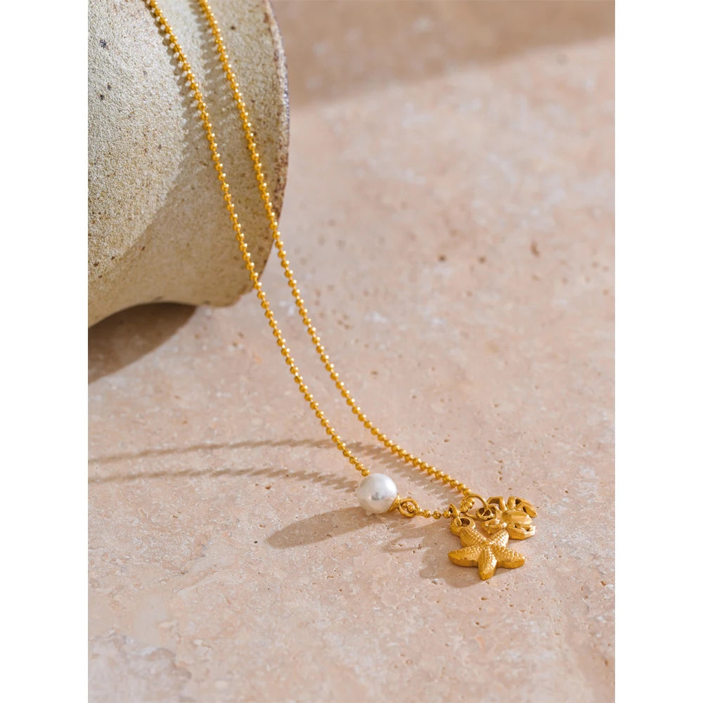 Collier à 3 breloques perle étoile et crabe doré