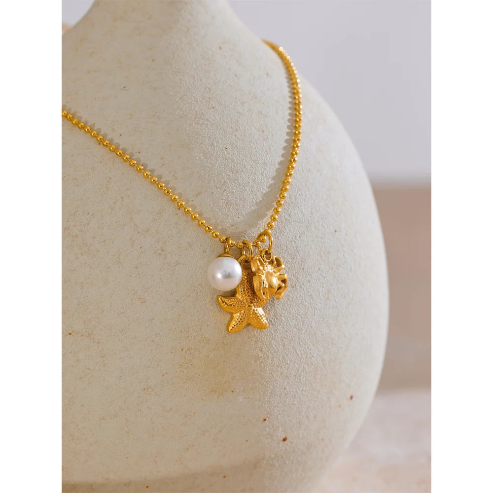 Collier à 3 breloques perle étoile et crabe doré