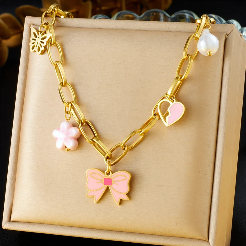 Collier à breloques doré et noeud papillon rose