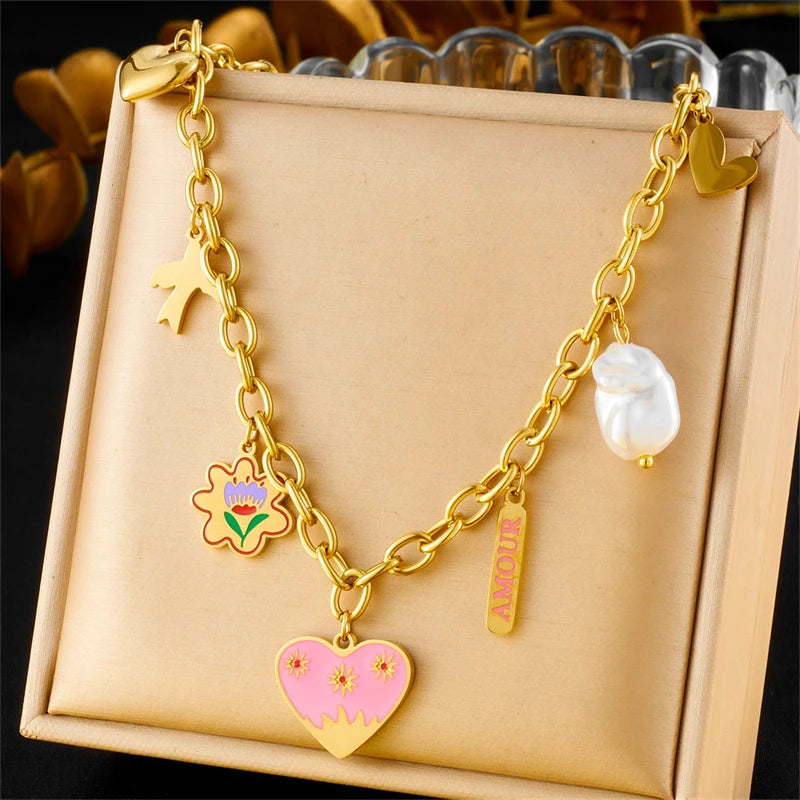 Collier à breloques doré et coeur rose