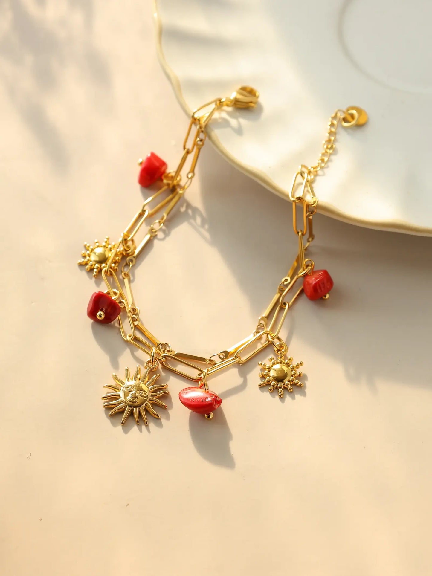 Bracelet à breloques avec soleil et pierres rouges