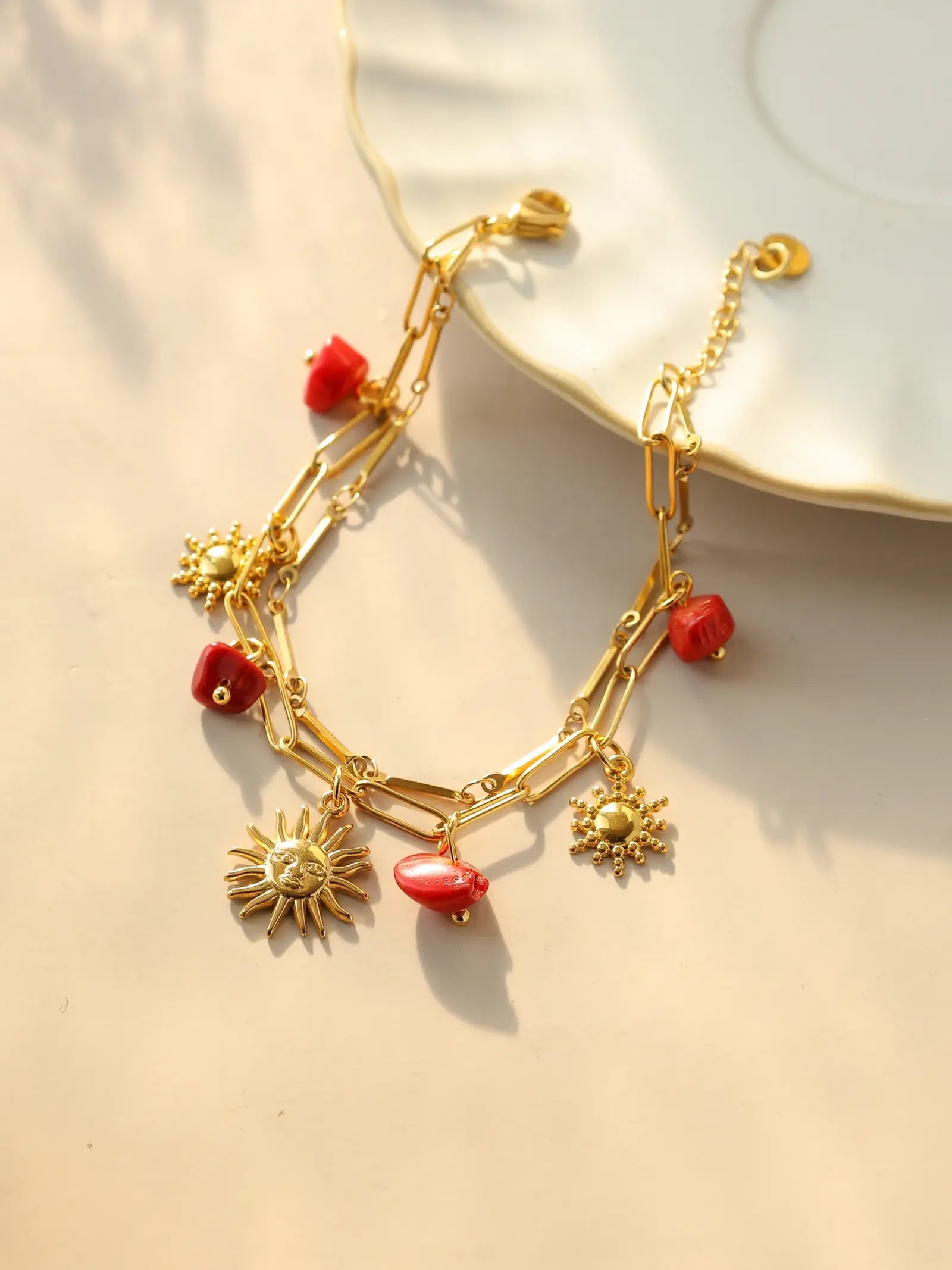 Bracelet à breloques avec soleil et pierres rouges
