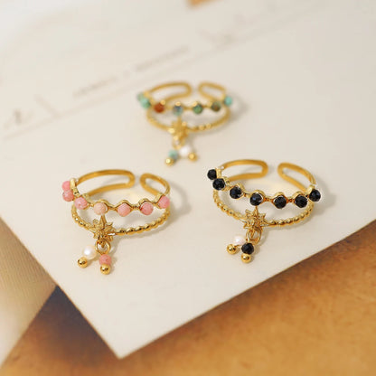 Bague à breloques blanches et noires dorée