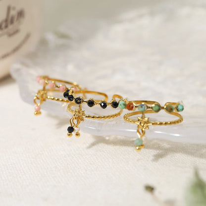 Bague à breloques blanches et noires dorée