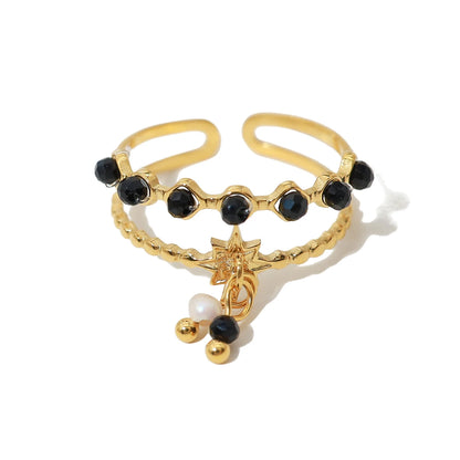 Bague à breloques blanches et noires dorée