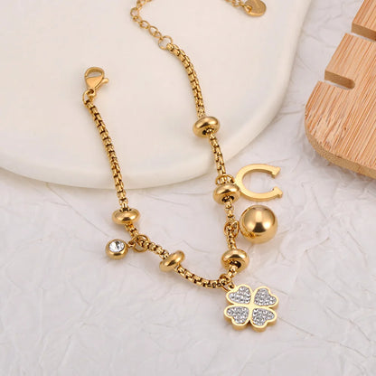 Bracelet à breloques doré avec trèfles et grelots