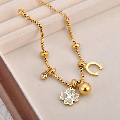 Bracelet à breloques doré avec trèfles et grelots