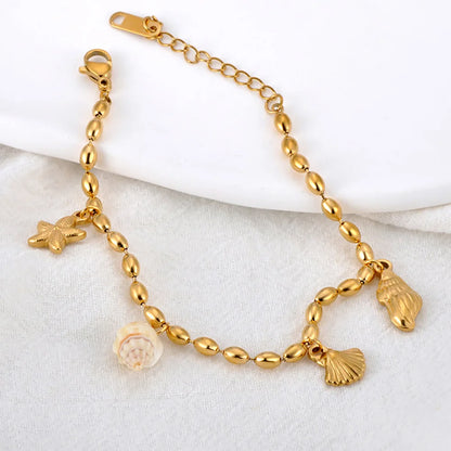 Bracelet doré à breloques avec coquillage