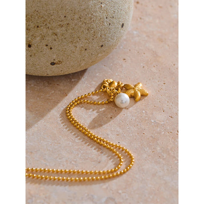 Collier à 3 breloques perle étoile et crabe doré