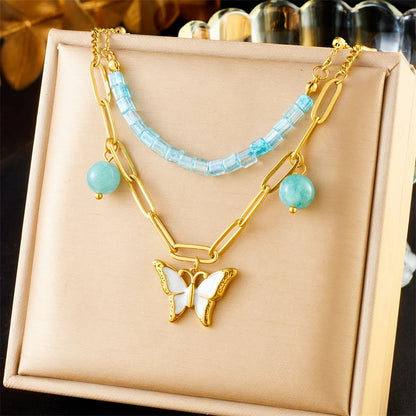 Collier à breloques doré papillon blanc et perles bleues