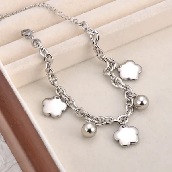 Bracelet à breloques argenté avec trèfles et grelots