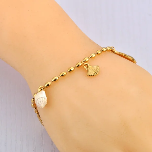 Bracelet doré à breloques avec coquillage