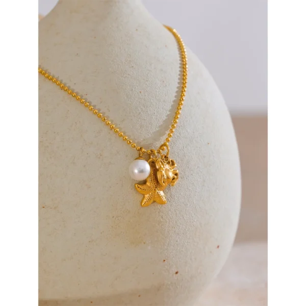 Collier à 3 breloques perle étoile et crabe doré