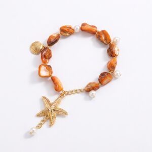 Bracelet bohème chic avec breloques étoile de mer, coquillage et perles nacrées sur fond blanc.