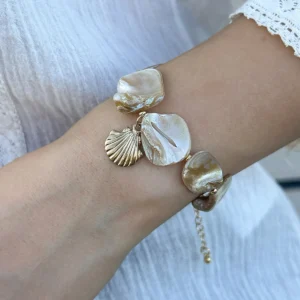 Bracelet bohème chic avec breloques en nacre et coquillage doré, parfait pour un look estival.