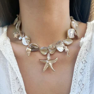 Collier breloque nacre et dorure, orné d'une étoile de mer et de coquillages, style bohème chic.